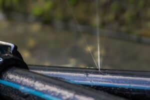 water squirting from a pinhole leak of black plastic HDPE plumbing pipe