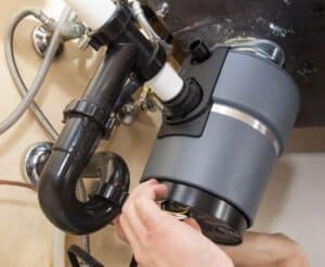 Resetting garbage disposal unit under kitchen sink to fix garbage disposal problems